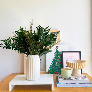 Classic Winter dried flower arrangement in forest green and frosted pods in a ribbed ceramic vase