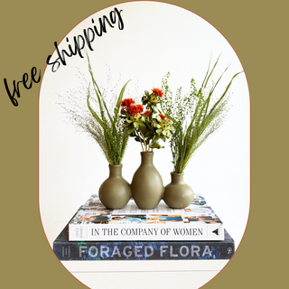 orange safflower, green explosion grass and pennycress dried flower arrangement in an olive ceramic bud vase, styled on a stack of books — House of Lilac